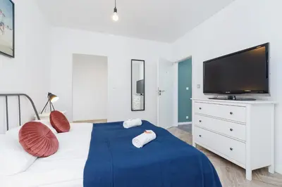a bedroom with a bed with a tv on a dresser at Premium Apartment Ludwinowska Kraków by Noclegi Renters in Kraków