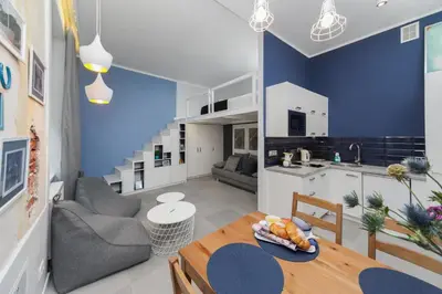 a kitchen and a living room with a dining table at Quiet & Comfortable Old Krakow Apartment in Kraków