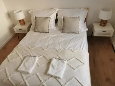 a bed with white sheets and pillows in a bedroom at Hygge House in Zator
