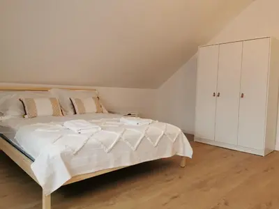 a bedroom with a white bed and a white cabinet at Hygge House in Zator