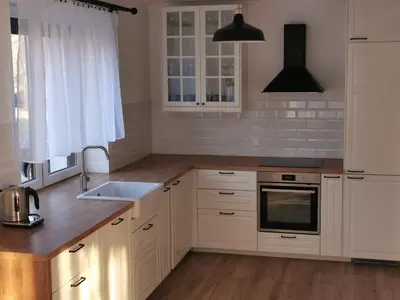 a kitchen with white cabinets and a sink at Hygge House in Zator