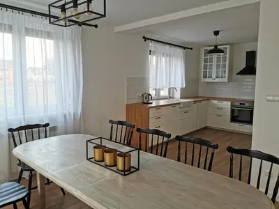 a kitchen and dining room with a table and chairs at Hygge House in Zator