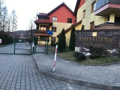 a building with a sign on the side of a street at APARTAMENT LUCYNA in Rabka