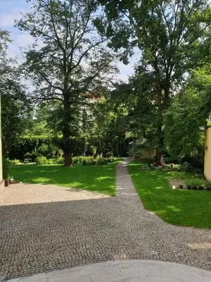 a walkway in a park with trees and grass at Apartament pod Wawelem in Kraków
