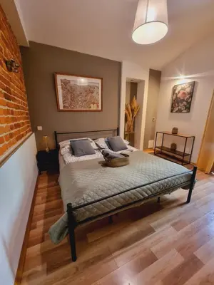 a bedroom with a bed and a brick wall at Apartament pod Wawelem in Kraków