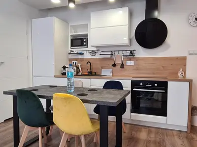 a kitchen with a table and chairs in a room at Paderewskiego Old Town Apartaments in Kraków
