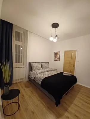 a bedroom with a bed with a black blanket at Paderewskiego Old Town Apartaments in Kraków