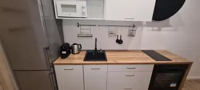 a kitchen with white cabinets and a sink and a refrigerator at Paderewskiego Old Town Apartaments in Kraków