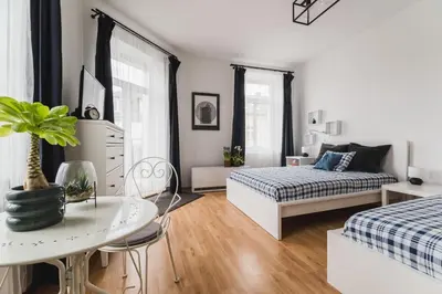 a white room with a bed and a table and a couch at Kawiory 2 in Kraków