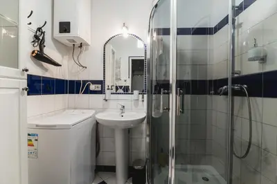 a white bathroom with a sink and a shower at Kawiory 2 in Kraków