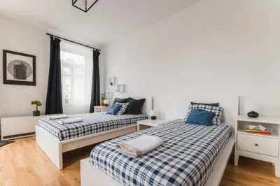 a bedroom with two beds and a window at Kawiory 2 in Kraków