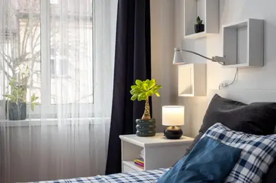 a bedroom with a bed with a lamp and a window at Kawiory 2 in Kraków