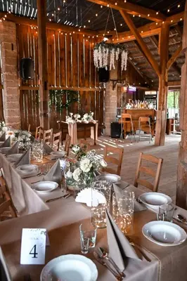 a dining room with tables and chairs in a barn at Pole Namiotowe Kogutowo in Wietrzychowice