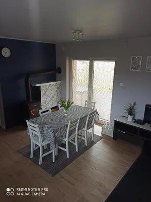a dining room table and chairs in a living room at Domek Całoroczny Pod Dworem in Wola Kalinowska
