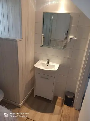 a bathroom with a sink and a mirror at Domek Całoroczny Pod Dworem in Wola Kalinowska