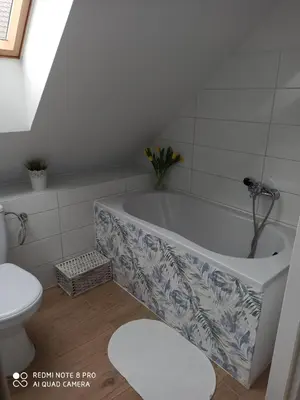 a bathroom with a bath tub and a toilet at Domek Całoroczny Pod Dworem in Wola Kalinowska