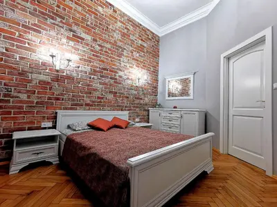 a bedroom with a brick wall and a bed at Apartament z Antresolą Kraków Kazimierz Bożego Ciała in Kraków