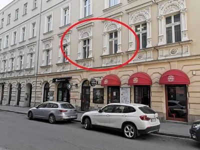 two cars parked in front of a building at Apartament z Antresolą Kraków Kazimierz Bożego Ciała in Kraków