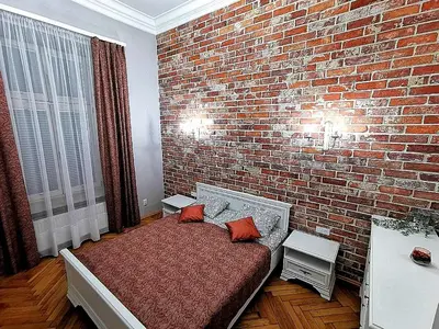 a bedroom with a brick wall and a bed with two pillows at Apartament z Antresolą Kraków Kazimierz Bożego Ciała in Kraków