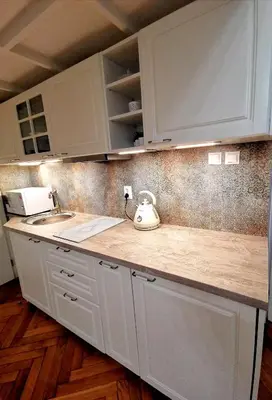 a kitchen counter with white cabinets and a tea kettle at Apartament z Antresolą Kraków Kazimierz Bożego Ciała in Kraków