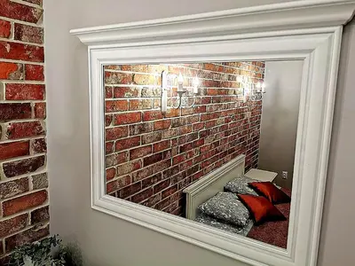 a mirror in front of a brick wall at Apartament z Antresolą Kraków Kazimierz Bożego Ciała in Kraków