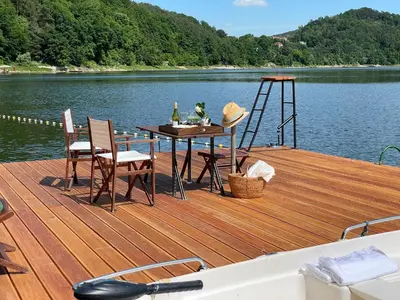 a wooden deck with a table and chairs on a boat at Rożnów domek pod Zamkiem in Rożnów