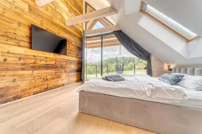 a bedroom with a large bed and a window at Pine Tree Chalet in Zawoja