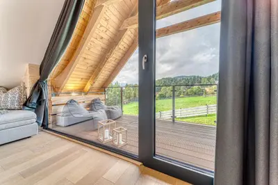 a room with a balcony with sliding glass doors at Pine Tree Chalet in Zawoja