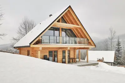 a log cabin in the snow at Pine Tree Chalet in Zawoja
