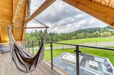 a hammock on the deck of a cabin at Pine Tree Chalet in Zawoja
