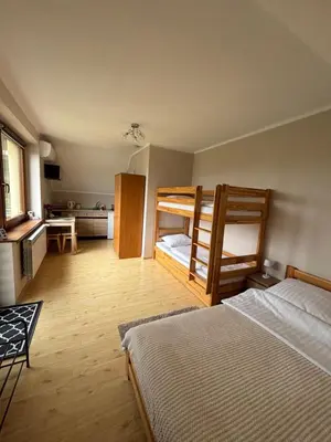a bedroom with two bunk beds and a kitchen at Azalia Zator in Zator