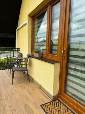 a porch with a bench and a door with a plant at Azalia Zator in Zator