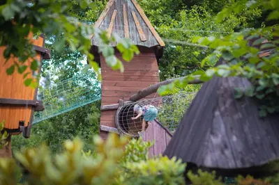 a person in a bird cage in a tree house at Hotel & SPA Czarny Groń in Rzyki