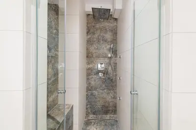 a shower with a glass door in a bathroom at Deluxe Apartment Rakowicka 15 WAWELOFTS in Kraków