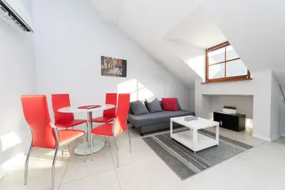 a living room with a table and red chairs at Exclusive Loft in the Main Square A/C p4you pl in Kraków