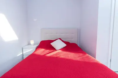 a bed with a red blanket and a white pillow at Exclusive Loft in the Main Square A/C p4you pl in Kraków