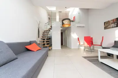a living room with a gray couch and red chairs at Exclusive Loft in the Main Square A/C p4you pl in Kraków