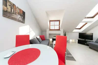 a living room with a white table and red chairs at Exclusive Loft in the Main Square A/C p4you pl in Kraków