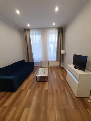 a living room with a blue couch and a tv at apartament in Kraków