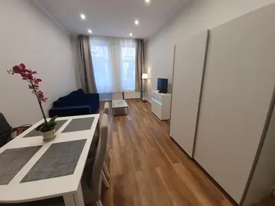 a living room with a table and a blue couch at apartament in Kraków
