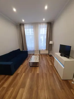 a living room with a blue couch and a tv at apartament in Kraków