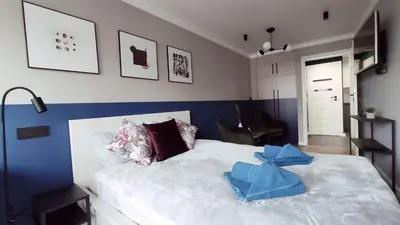 a bedroom with a white bed and a blue wall at Kremerowska 9 by Homeprime in Kraków