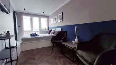 a bedroom with a bed and two chairs and a window at Kremerowska 9 by Homeprime in Kraków