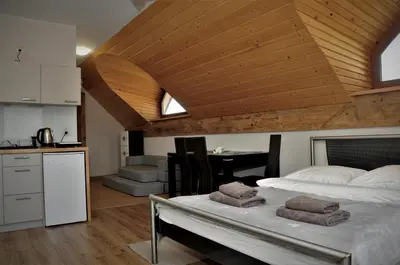 a bedroom with a large bed with a wooden ceiling at Lipowe Wzgórze Limanowa in Limanowa