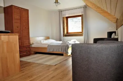 a bedroom with a bed and a window at Lipowe Wzgórze Limanowa in Limanowa