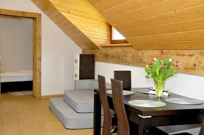 a dining room with a table and chairs and a bed at Lipowe Wzgórze Limanowa in Limanowa