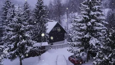 a house covered in snow in front of trees at Zawoja Dom Czatoża in Zawoja