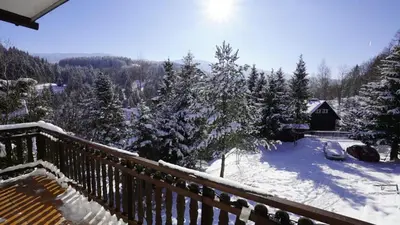 a balcony with snow covered trees and a cabin at Zawoja Dom Czatoża in Zawoja