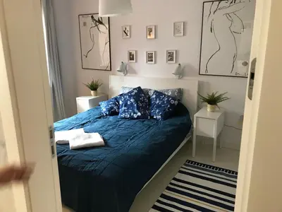 a bedroom with a bed with blue sheets and pillows at Browar Lubicz 17b apartament 11 by Atrium Apartments in Kraków