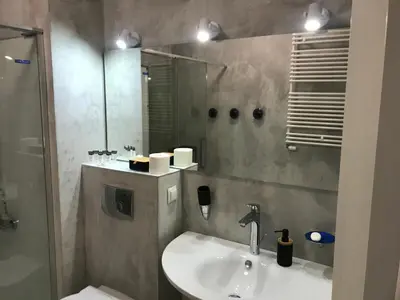a bathroom with a sink and a shower and a mirror at Browar Lubicz 17b apartament 11 by Atrium Apartments in Kraków